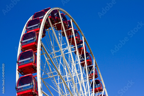 Red and white ferris wheel on a blue sky