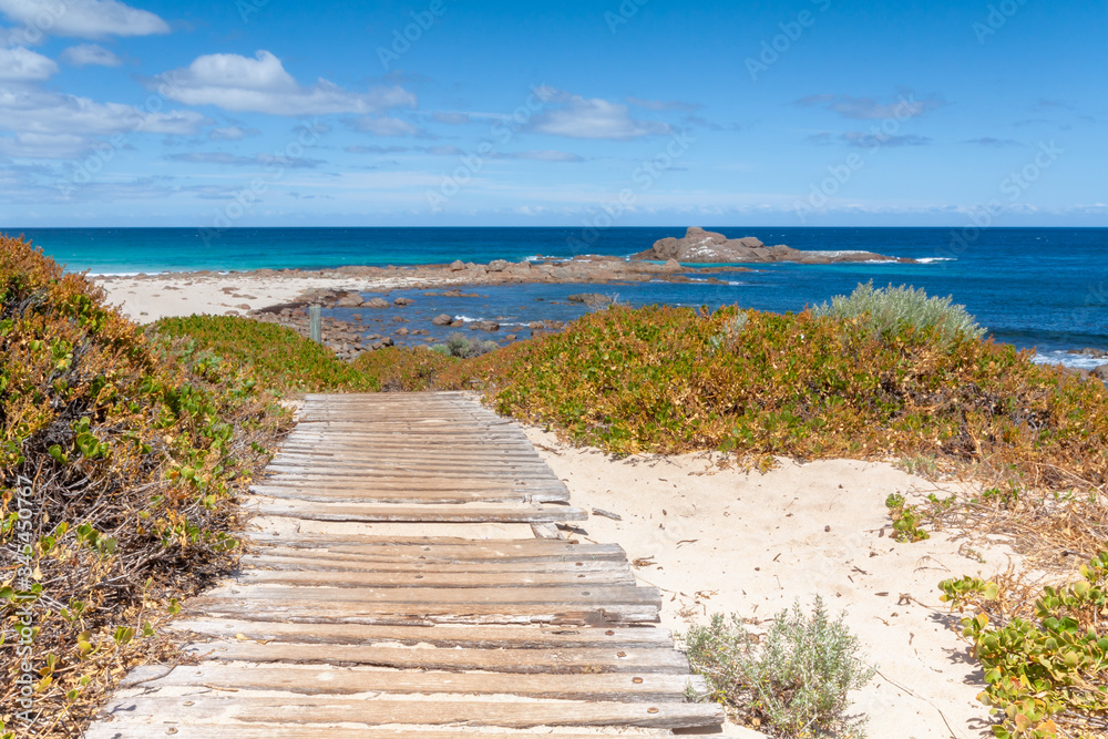 Wooden walkway to the beach through the sand dunes