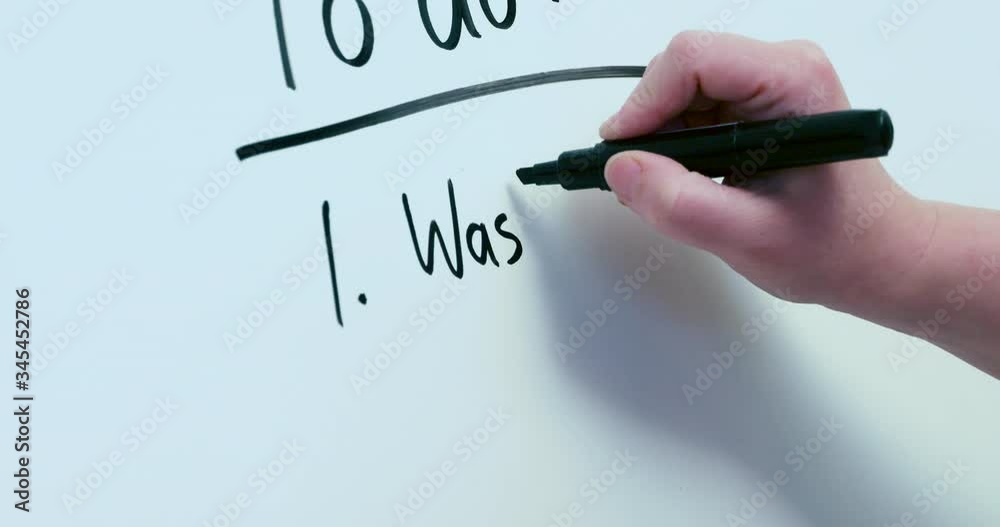 Writing a list of tasks on a whiteboard.