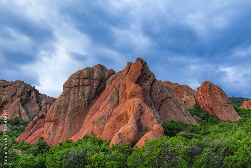 Red mountains rising from the green trees during sunset
