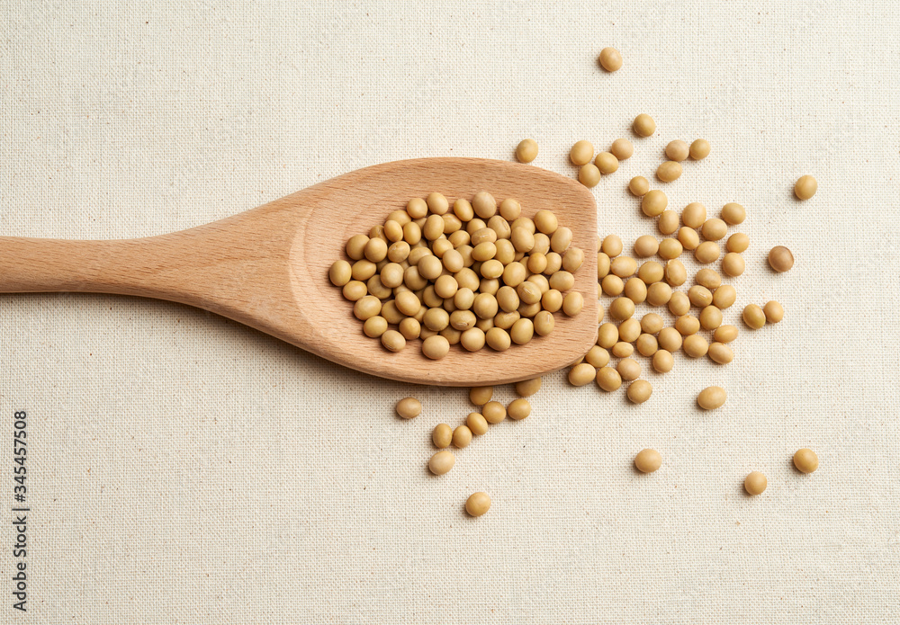 top view of soybean in wooden spoon on gunny textile background top view of soybean in wooden spoon on gunny textile background