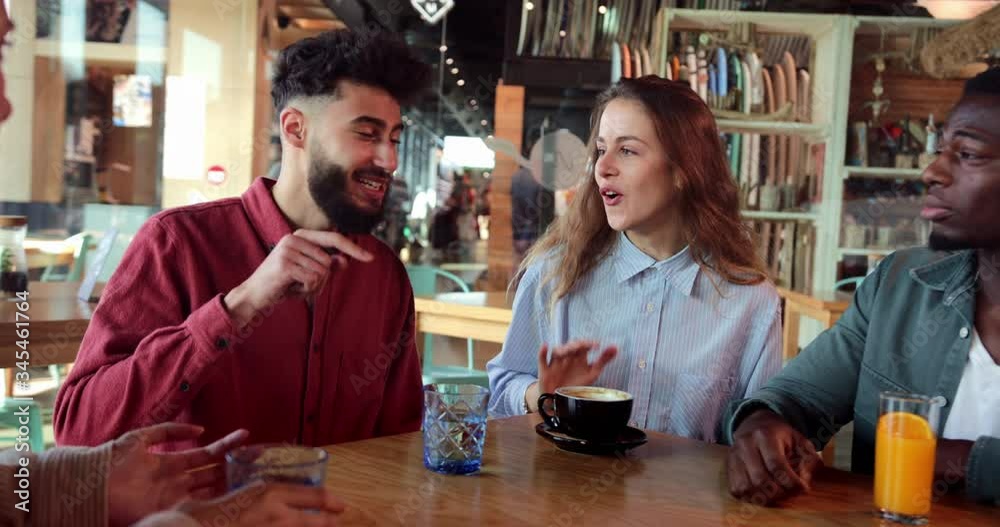 Multi-ethnic group of friends talking and hanging together at cafe Multi-ethnic group of friends talking and hanging together at cafe