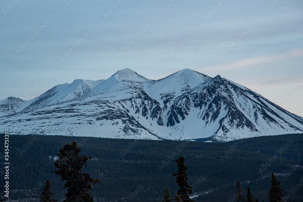 Stunning mountains seen in northern Canada, Yukon Territory at sunset in the winter with snow capped peaks. 
