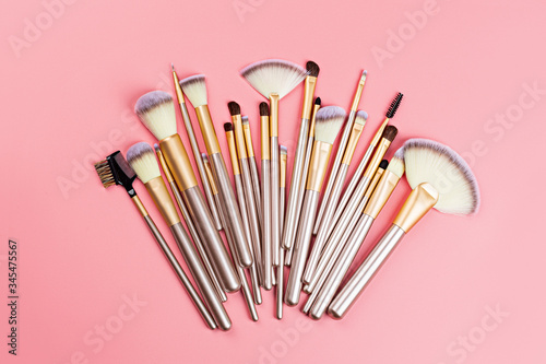 Cosmetic Makeup brushes on pink background. Flat lay, top view, copy space.