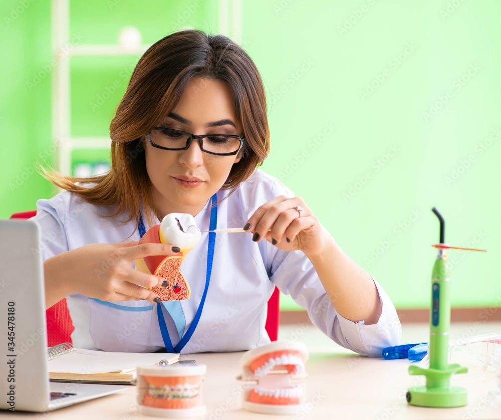 Woman dentist working on teeth implant