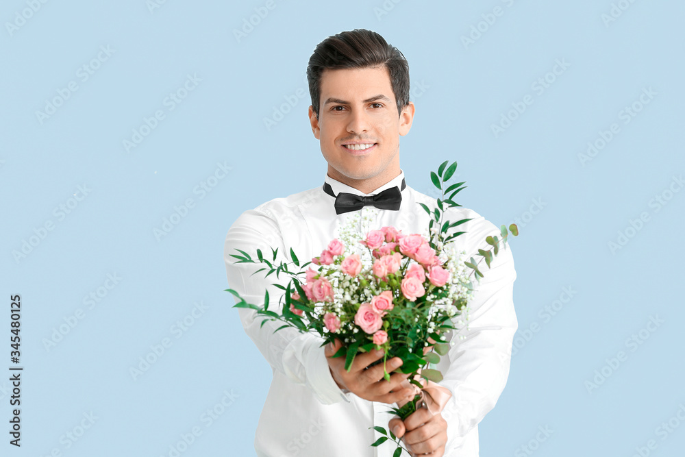 Handsome man with bouquet of flowers on color background Handsome man with bouquet of flowers on color background
