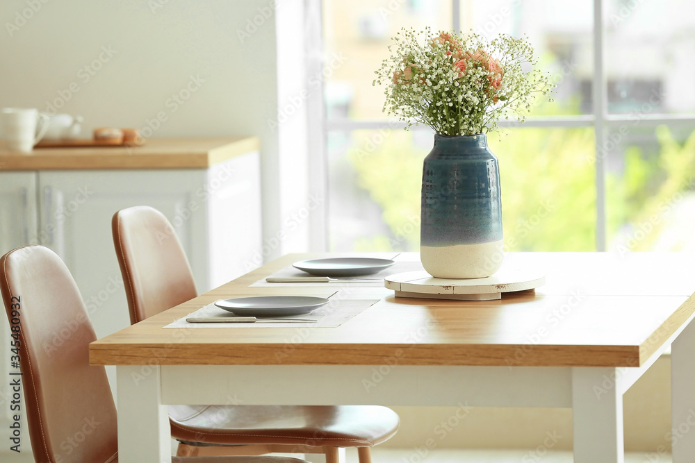 Stylish vase with bouquet of flowers in interior of kitchen