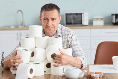 Mature man with heap of toi...