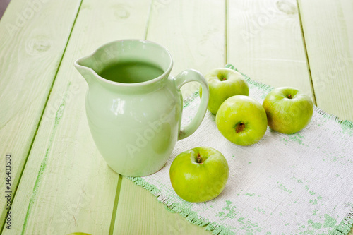 Ripe green apples on a green napkin lying on a canvas napkin and a wooden table surface. Background for fruits.