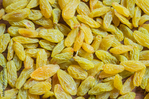 Green raisins spread on kitchen counter. Green raisin background.