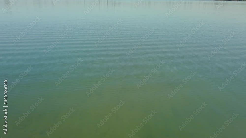Aerial drone shot of flying low at the lake and moving forward revealing the suburban near the lake in the Netherlands. Aerial drone shot of flying low at the lake and moving forward revealing the suburban near the lake in the Netherlands.