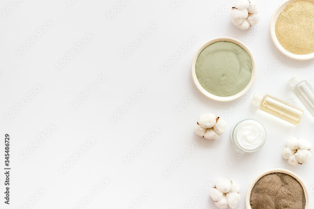 Set of cosmetic clays for facial beauty face mask on white table top-down frame space for text