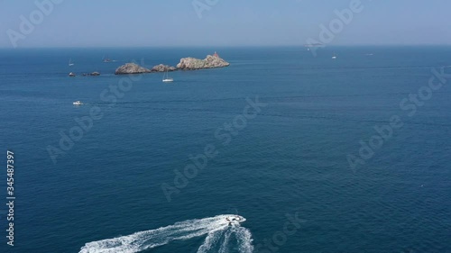 Two Jet Skis cruising toward beautiful little Island Grebeni near city of Dubrovnik in Croatia, surrounded with tirkiz Blue Sea - Aerial Drone Panoramic View photo