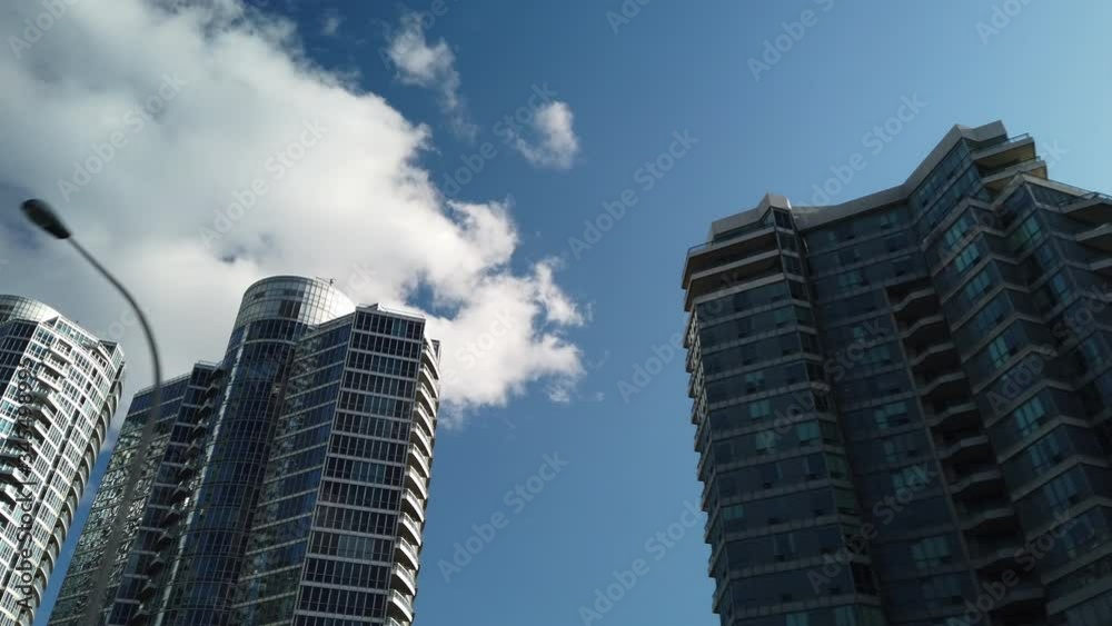 Travelling wide shot of shiny, reflective condo towers in Toronto, shot from below Travelling wide shot of shiny, reflective condo towers in Toronto, shot from below
