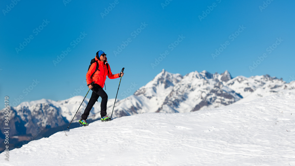 A lonely woman walks on the snow with crampons