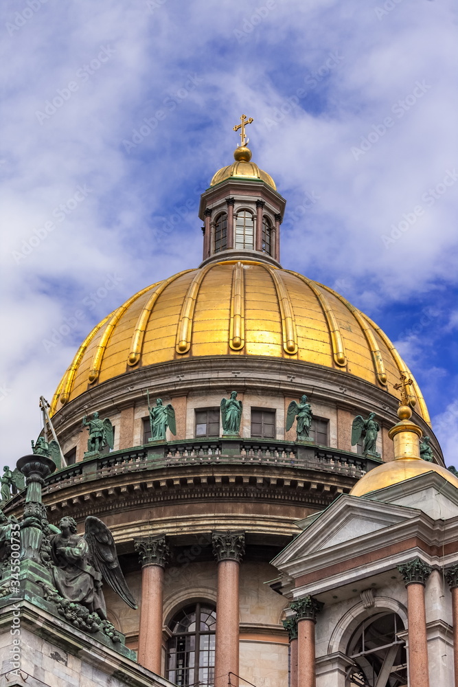 Dome with copper figures on the building of St. Isaac's Cathedral in St. Petersburg Russia against the sky with clouds