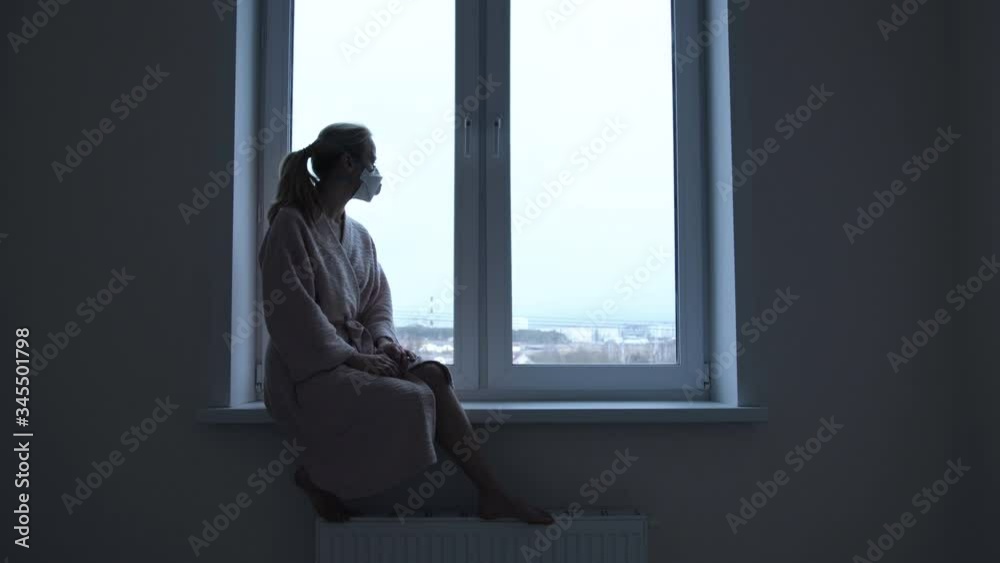 Girl sitting on a windowsill in a white room Girl sitting on a windowsill in a white room