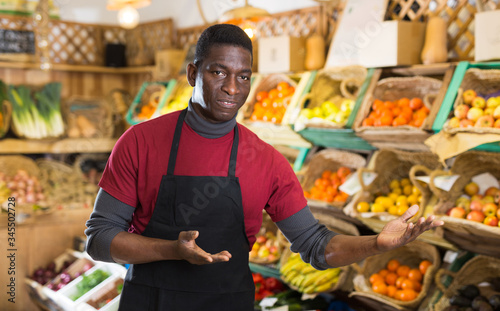 Salesman inviting to fruit and vegetable store