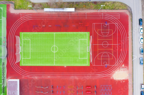 Football and basketball field with treadmills, horizontal bars and other outdoor fitness equipment on the sports ground in the courtyard of residential buildings.
