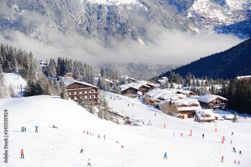 Courchevel ski resort, Rhône-Alpes, France by winter with skiers on the slopes 