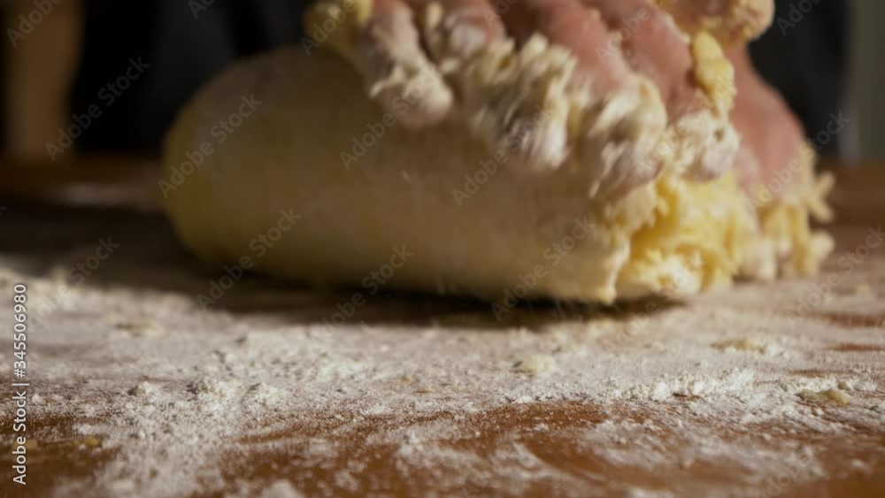 4K close up slow motion shot raw gnocchi dough kneaded by hand on a wooden table 4K close up slow motion shot raw gnocchi dough kneaded by hand on a wooden table