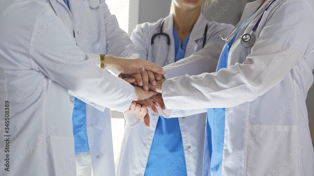 Team of medical workers holding hands together indoors, above view. Unity concept Team of medical workers holding hands together indoors, above view. Unity concept