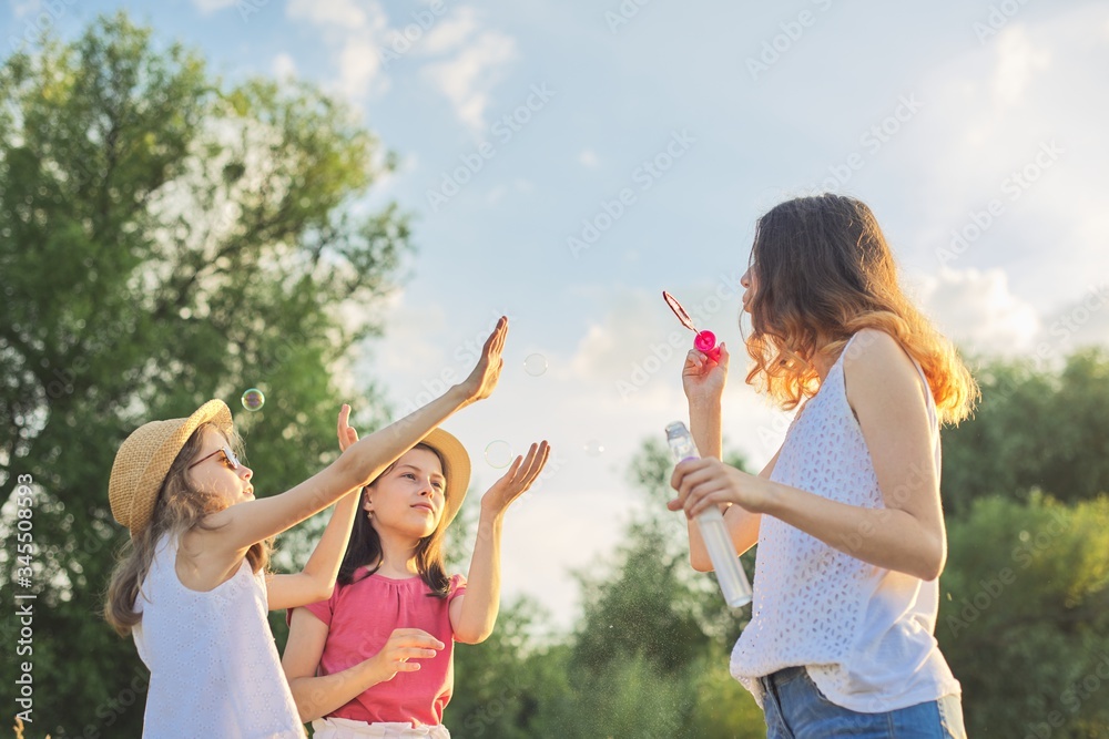 Obraz premium Children three girls playing with soap bubbles