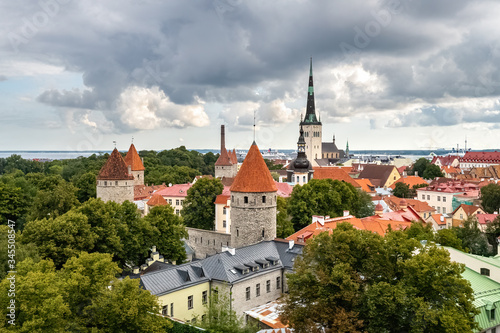 Summer panoramic view of Saint Nicholas Church tower and Toompea hill. Old town of Tallinn with red rooftops, Estonia
