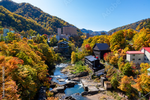 札幌市・定山渓温泉にて定山渓大橋から色とりどりの紅葉に染まる山と豊平川を眺める