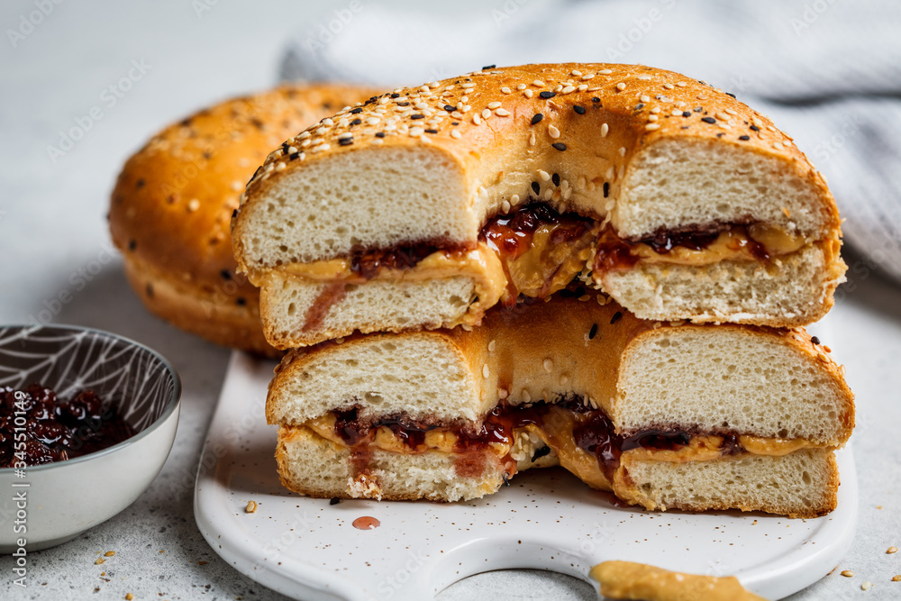 Bagels with peanut butter and berry jam on white board. Vegan food concept. Bagels with peanut butter and berry jam on white board. Vegan food concept.