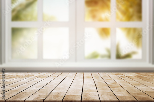 wood table place and window with  palm leaves against with sun light
