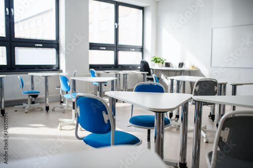 Desks and chairs in empty classroom. Copy space.