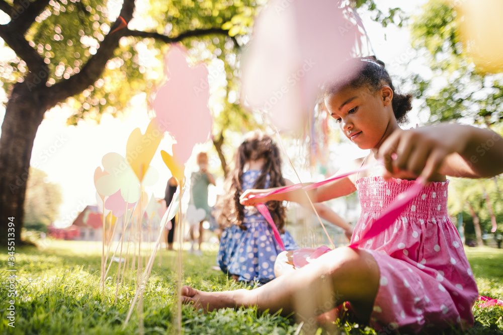 Fototapeta premium Small children outdoors in garden in summer, playing.