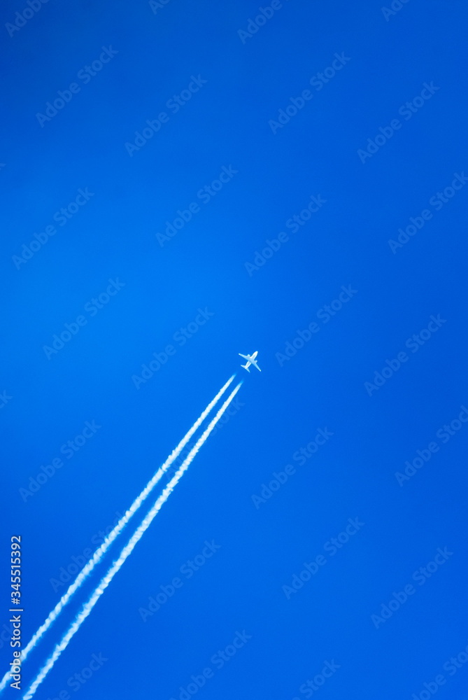 The trace of a flying plane in the blue sky The trace of a flying plane in the blue sky