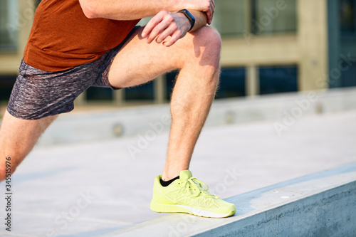 Young man exercising / stretching in urban park.