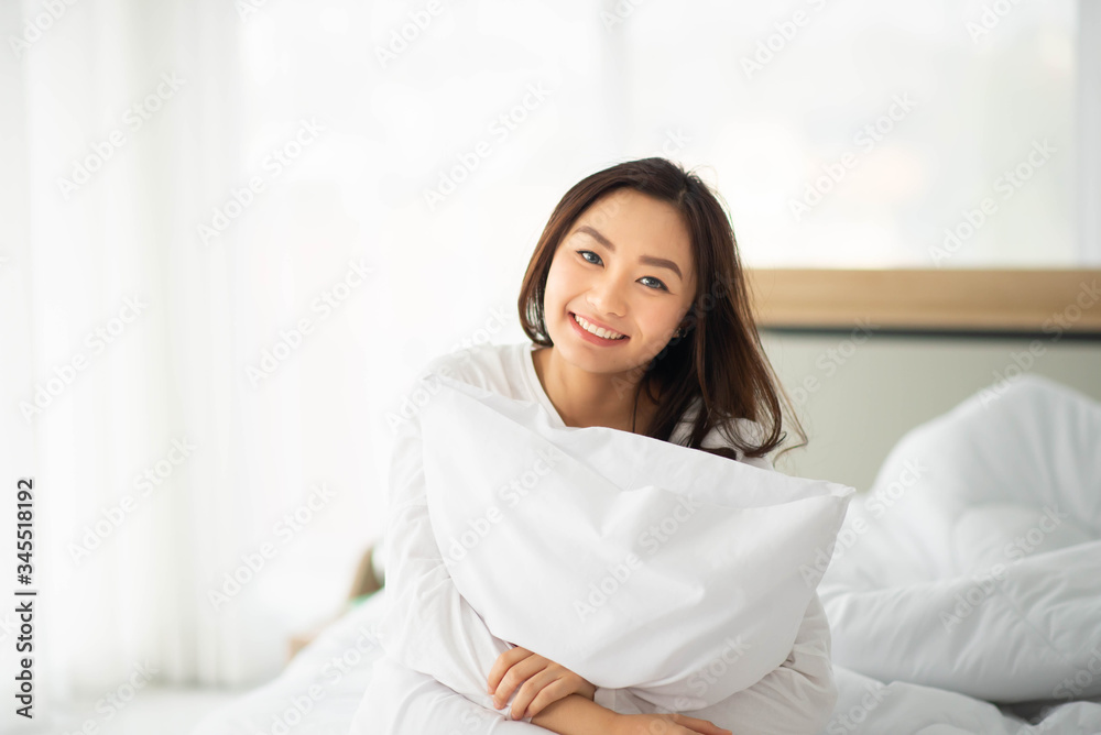 Asian woman hug the pillow in the bed smile and happy Asian woman hug the pillow in the bed smile and happy