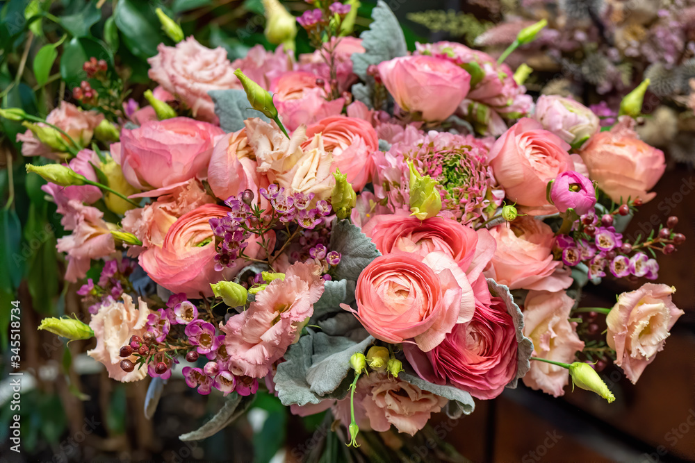 Close-up of beautiful multi-colored bouquet of mixed roses and other flowers in a shop. Fresh cut flowers.