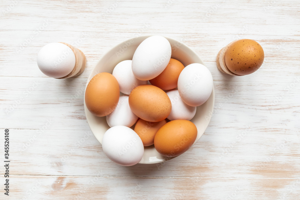 Free-range organic brown and white eggs in bowl on wood background with copy space Free-range organic brown and white eggs in bowl on wood background with copy space