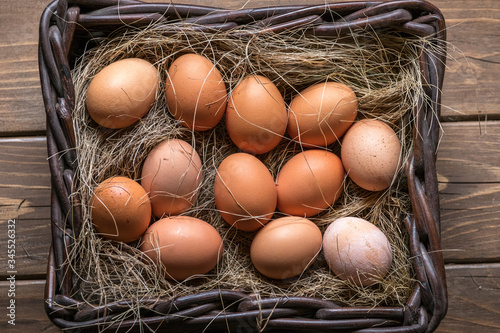 organic eggs in wicker basket fresh raw food on rustic wooden farm background
