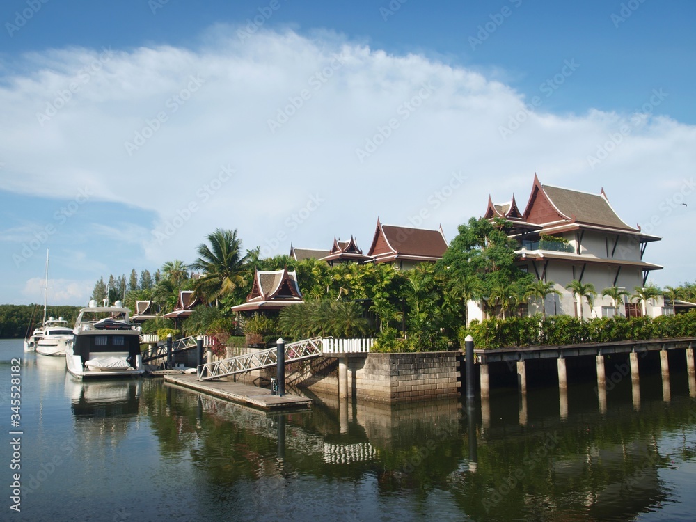 Luxury residential street to the sea bay. Panoramic view of houses, yachts and villas. Rich homes with a personal piers. Coastal city, town. Buildings in style of traditional Asian architecture