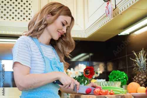 Young woman in the kitchen preparing a salad