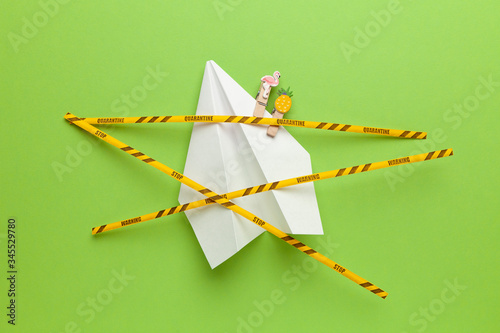 Paper airplane on green background under quarantine. Cancellation of flights of civil and touristic aviation. Crisis of air travel.