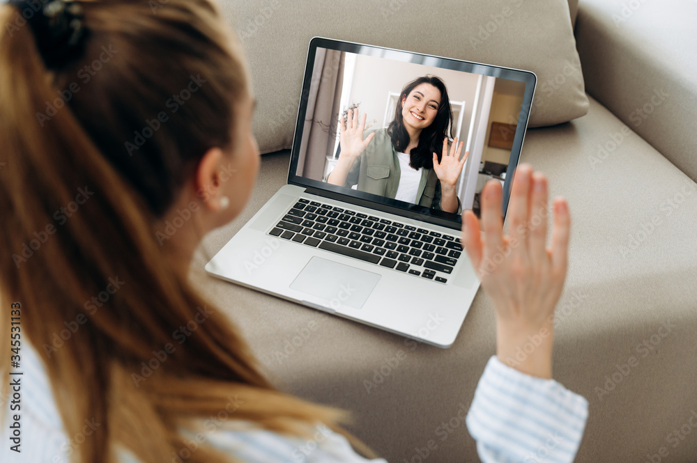 Video call. Two young attractive girls communicate via video communication in zoom app using a laptop. Online meeting with friend Video call. Two young attractive girls communicate via video communication in zoom app using a laptop. Online meeting with friend