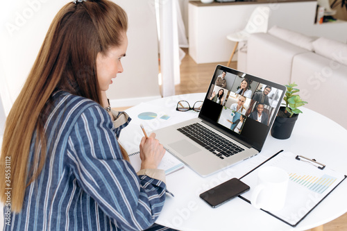 Video call. Remote work. Successful businesswoman works from home. She communicate via video communication with colleagues using laptop. Online conference