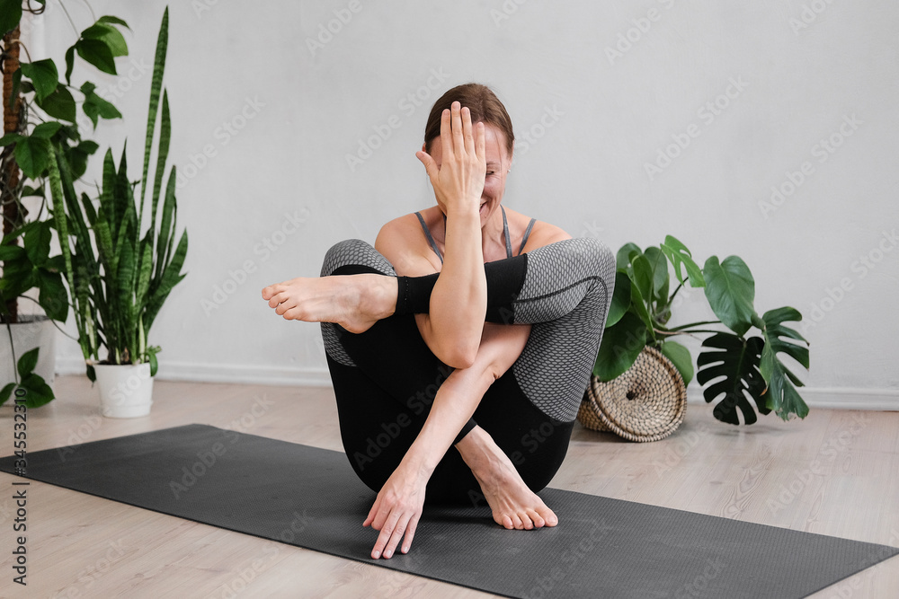 A woman does hatha yoga at home during the quarantine A woman does hatha yoga at home during the quarantine