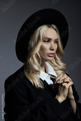 Portrait of a Blonde woman in a big round black hat, hair styling