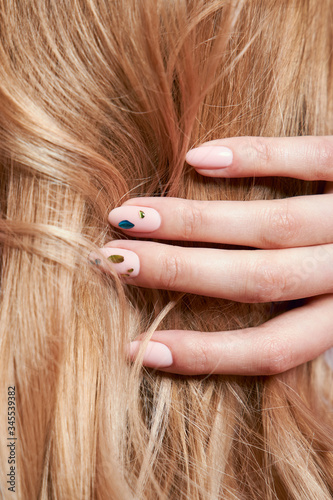 Beautiful strong hair of a woman, strengthening and restoring the hair roots. Beautiful manicure on the hands of a girl