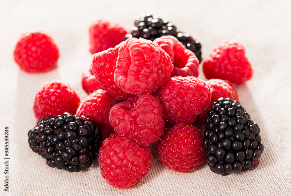 handful of fresh raspberry and blackberry berries on white background handful of fresh raspberry and blackberry berries on white background