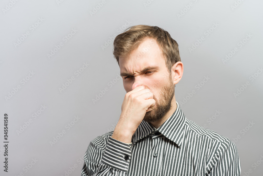 Closeup portrait of young man, disgust on face, pinches his nose, something stinks very bad smell, situation, asking is it you, isolated on gray background. Negative emotion facial expression feeling Closeup portrait of young man, disgust on face, pinches his nose, something stinks very bad smell, situation, asking is it you, isolated on gray background. Negative emotion facial expression feeling
