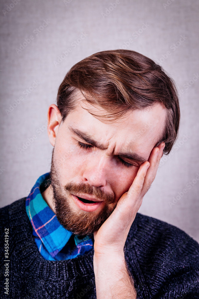 young man with beard in blue sweater dozing young man with beard in blue sweater dozing